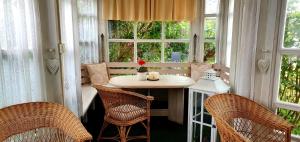 Zimmer mit einem Tisch, Stühlen und Fenstern in der Unterkunft Pension Elbrs in Marienbad