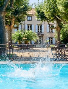 une fontaine dans une piscine en face d'un bâtiment dans l'établissement Domaine Des Agnelles, à Villedaigne