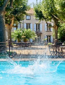 uma fonte numa piscina em frente a um edifício em Domaine Des Agnelles em Villedaigne