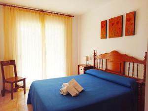 - une chambre avec un lit bleu et des serviettes dans l'établissement Village Golf Beach, à Pals