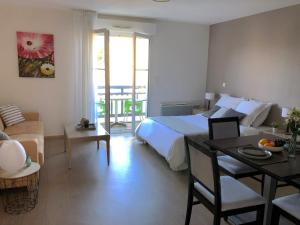 una habitación de hotel con una cama y una mesa y una habitación en Guilvinec Parc Residence, en Le Guilvinec
