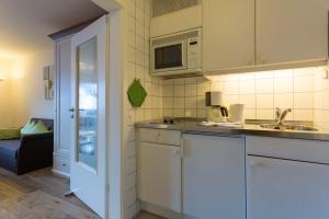 a kitchen with a sink and a microwave at Ferienwohnung Boland in Oberstdorf