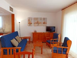 a living room with a blue couch and a tv at Village Golf Beach in Pals