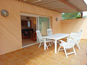 - une table et des chaises blanches sur la terrasse dans l'établissement Village Golf Beach, à Pals
