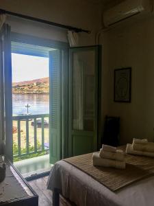 a bedroom with a bed with a view of the water at The house in the port in Korissia
