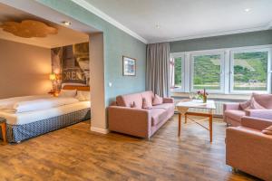Habitación de hotel con cama y sofá en Weinhotel Landsknecht en Sankt Goar