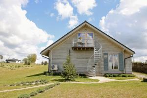 a house with a balcony on the side of it at Lavender Village in Kiemeliai
