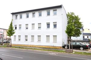 ein weißes Gebäude an der Straßenseite in der Unterkunft Apartment Hotel Wittenau in Berlin