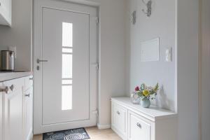 a kitchen with a white door and a vase of flowers at Villa Vineta in Kühlungsborn