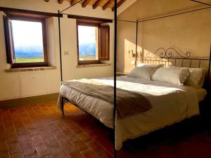 una camera con un letto e due finestre di Agriturismo Sole a Trequanda