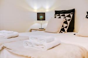 2 Betten mit weißen Handtüchern auf einem Zimmer in der Unterkunft Casa Azul Traditional House - Faro in Faro