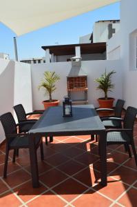 einen schwarzen Tisch und Stühle auf einer Terrasse in der Unterkunft Apartamento PLAYA HONDA I - Home Beach in Playa Honda