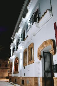 - un bâtiment blanc avec une porte et une arche dans l'établissement Hotel Avenida Playa, à Zahara de los Atunes