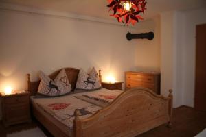 ein Schlafzimmer mit einem Bett mit zwei Kommoden und einem Kronleuchter in der Unterkunft Buchschneider - Ferienhaus Maier - Landhof in Schwarzautal