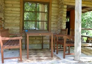 a wooden table and chairs in front of a cabin at Löydön Kartano Camping in Mikkeli