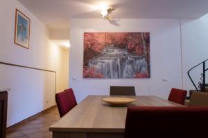 een eetkamer met een tafel en een schilderij aan de muur bij Villa Nicol affittacamere in Marina di Ragusa