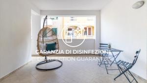 a living room with a chair and a table at Italianway - Ottoventi Apartments in Lampedusa