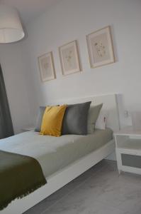 a bed with yellow and grey pillows in a room at Mirafondo Beach in Playa Honda