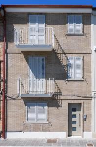 a brick building with stairs and windows on it at Civico 43c in Porto San Giorgio