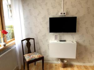 a room with a chair and a television on a wall at Villa Frideborg in Henån