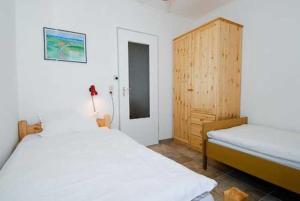 1 dormitorio con 2 camas y armario de madera en Ferienhaus Nordwind en Bensersiel