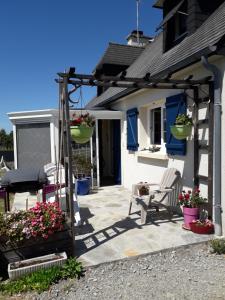 a patio with two chairs and a pergola at Maison Entre Terre et Mer in Primelin