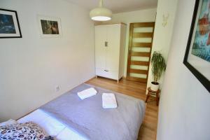 a bedroom with a bed with two towels on it at Apartament Bazatatry Słoneczny in Zakopane