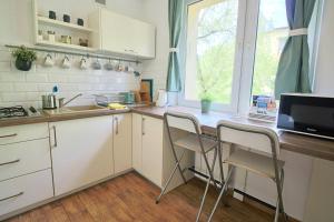 a kitchen with white cabinets and a table and chairs at Apartament Bazatatry Słoneczny in Zakopane