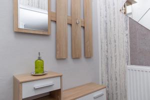 a bathroom with a table with a green bottle on it at Ferienwohnungen Schorn in Burg an der Mosel +40 photos