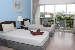 a hotel room with two beds and a balcony at Orchid Residence Samui in Chaweng