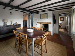 a kitchen and dining room with a wooden table and chairs at Dog Cottage in Little Barningham