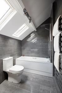 a bathroom with a toilet and a bath tub at Dog Cottage in Little Barningham