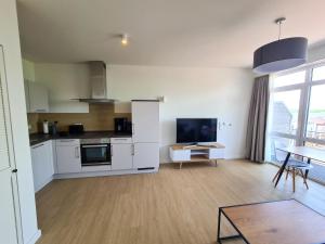 a kitchen with white cabinets and a table in a room at Apartments Gezeitenfluss in Tönning