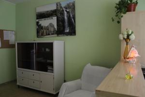 sala de estar con TV y silla en Albergue Turístico Silleda, en Silleda