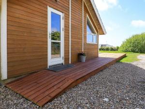 een houten terras aan de zijkant van een huis bij 6 person holiday home in Vestervig in Vestervig