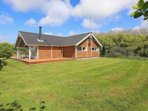 een houten huis met een grote tuin ervoor bij 6 person holiday home in Vestervig in Vestervig