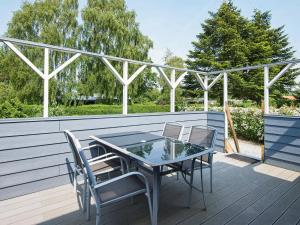 un patio con mesa y sillas en una terraza en 4 person holiday home in Juelsminde, en Snaptun