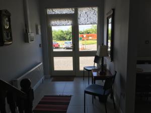 a hallway with an open door with a table and chairs at The Foxes Covert in Multyfarnham