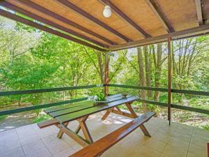 a picnic table on a screened in porch with a bench at Cozy Chalet in Trois Ponts with Forest Near in Trois-Ponts