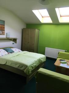 a green room with two beds and a table at Penzion starojicka pizza in Starý Jičín