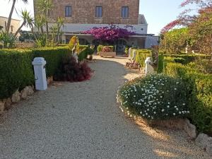 a garden with bushes and flowers and a building at Agriturismo Tenuta Mazzetta in Mesagne