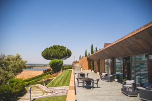 a patio with tables and chairs next to a building at Castillo de Monte la Reina Posada Real & Bodega in Toro