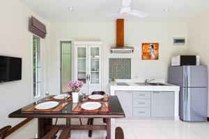 拉威海灘的住宿－Residence Harmonie，厨房配有桌子和冰箱