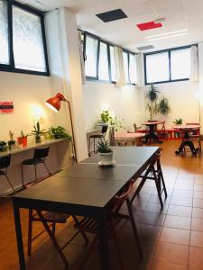 Bilbao Akelarre Hostel في بلباو: طاولة وكراسي في غرفة بها نوافذ