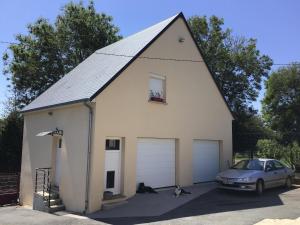 a car parked in front of a white garage at chez diane in Barbeville