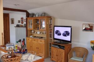 uma sala de estar com uma televisão de ecrã plano num armário de madeira em La Maison de Vacances em Nothalten