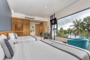 um quarto de hotel com duas camas e uma grande janela em An Phu Hotel em Phu Quoc