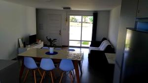 sala de estar con mesa y 4 sillas azules en CASA EM CONDOMÍNIO - 3 dormitórios - LAZER COMPLETO - Xangri-lá en Xangri-lá