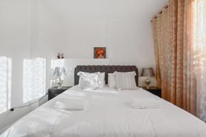 1 dormitorio con 1 cama blanca grande con almohadas blancas en KOZYGURU Belrose Modern Designer 2 Bed FREE Parking NBE007, en Belrose