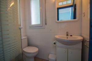 a bathroom with a sink and a toilet and a window at Agi Marina Apartments in Roses +24 photos